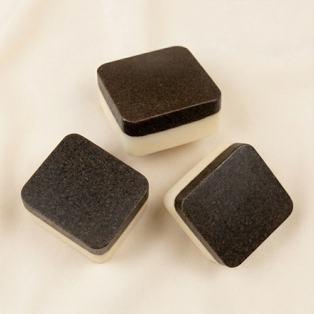 Three 2nd Ground bars on linen, each showing the dark upcycled coffee scrub side above the cream soap side